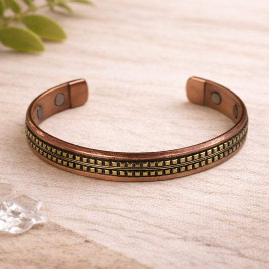 Copper bracelet with decorative elements on a light fabric background