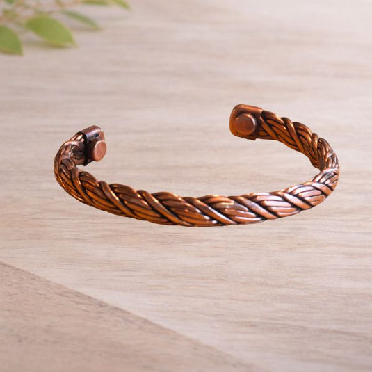 Copper bracelet on a light wooden surface