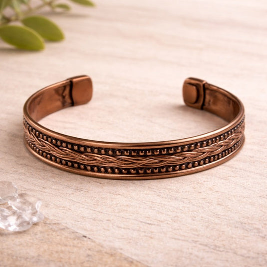 Bronze bracelet on a light wooden surface with a blurred background
