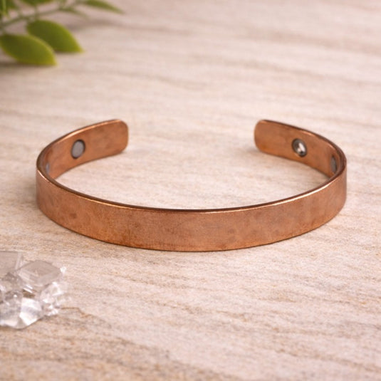 Copper bracelet on a textured surface with a natural background