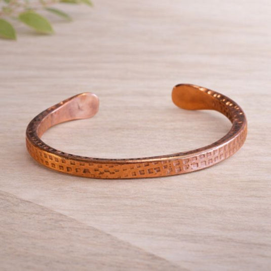 Copper bracelet on a light wooden surface