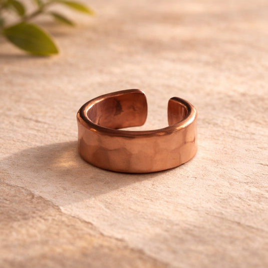 Copper bracelet on a textured beige surface with a soft focus background
